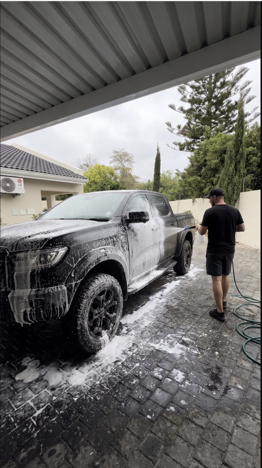 Black Ford Ranger covered in snow foam during a mobile wash